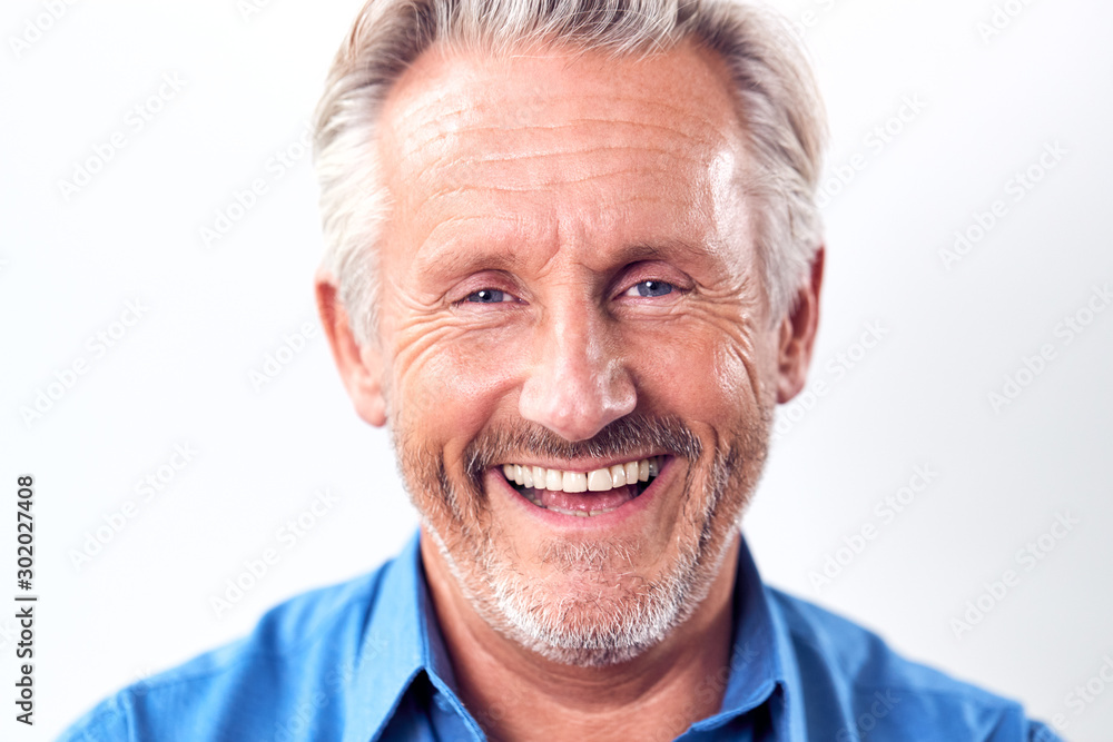 Studio Shot Of Mature Man Against White Background Laughing At Camera Studio Shot Of Mature Man Against White Background Laughing At Camera