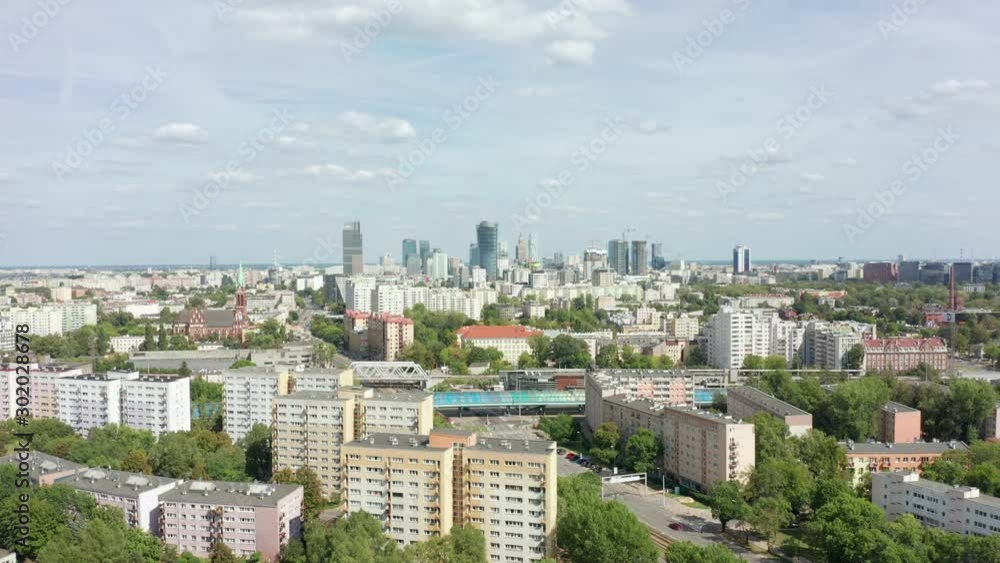 Drone flies towards buildings and skyscrapers in the city of Warsaw, Poland. Aerial view of the cityscape with streets and public transport. Drone flies towards buildings and skyscrapers in the city of Warsaw, Poland. Aerial view of the cityscape with streets and public transport.