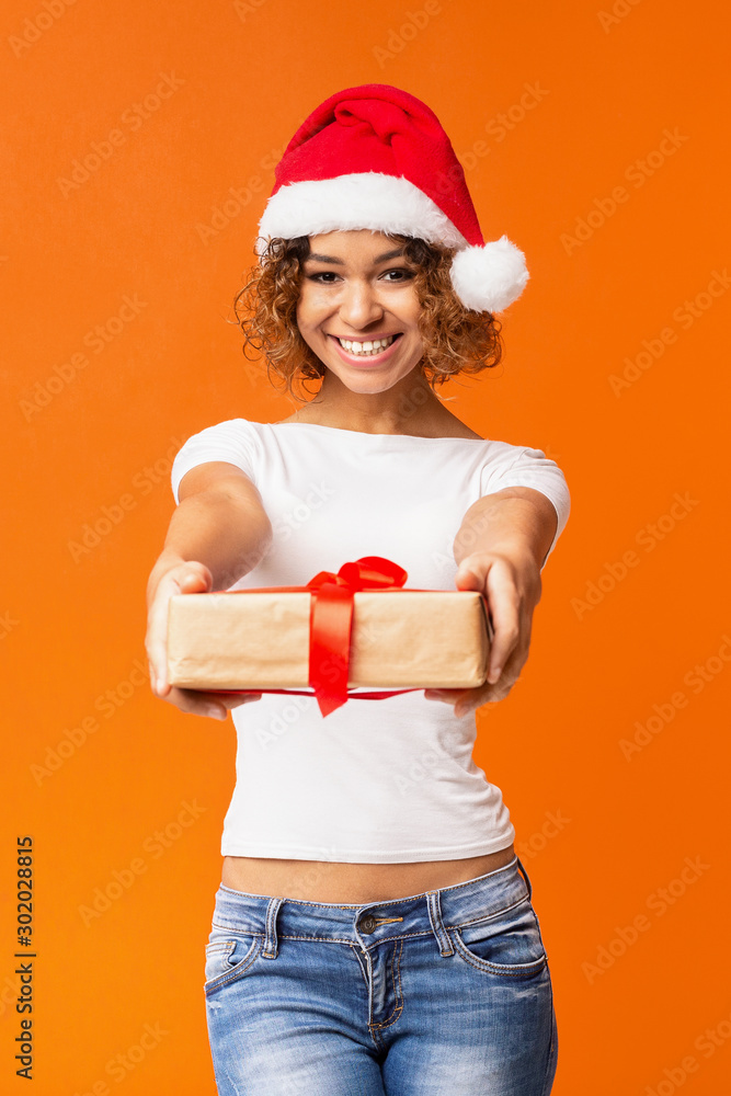 Beautiful african-american girl in Santa hat holding presents Beautiful african-american girl in Santa hat holding presents