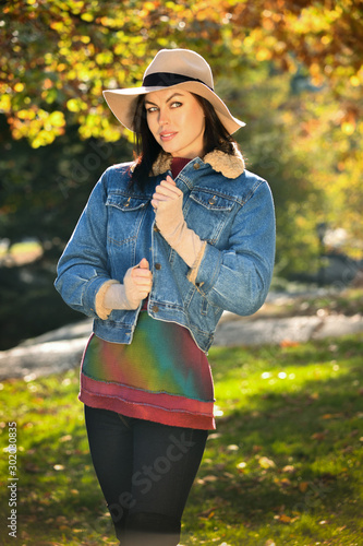 Fototapeta Naklejka Na Ścianę i Meble -  Fashionable young woman in autumn park. Warm sunny weather. Fall concept