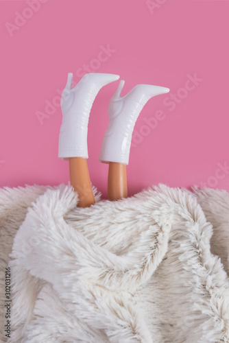 Fotografia, Obraz Doll's legs sticking out from under synthetic white fur