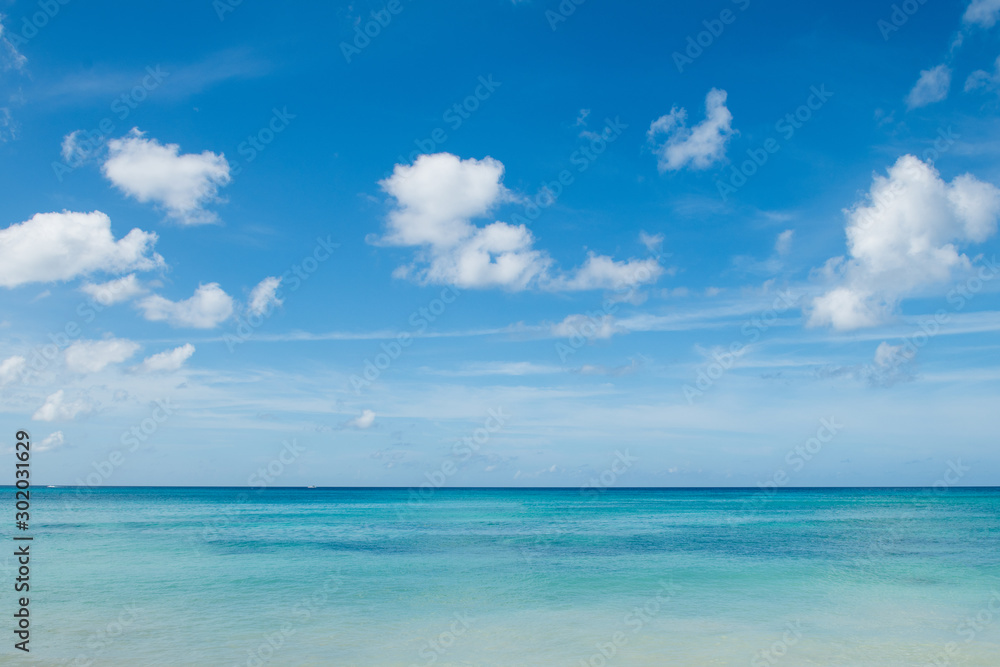 Caribbean landscape: azure sea, deep blue sky and white small clouds