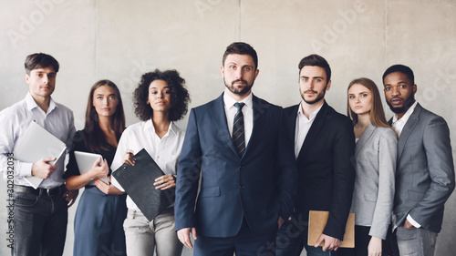 Millennial business colleagues headed with boss, posing to camera