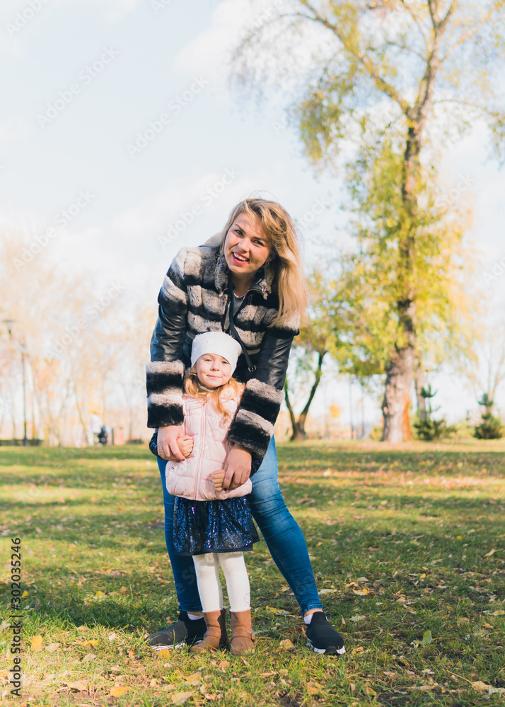 Fototapeta premium Happy mother and her daughter spending time in the autumn city park. Concept of Mother Day