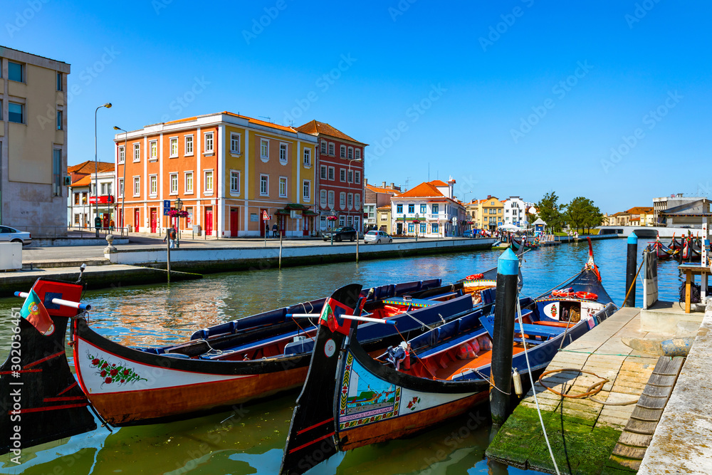 Traditional boats on the canal in Aveiro, Portugal. Colorful Moliceiro boat rides in Aveiro are popular with tourists to enjoy views of the charming canals. Aveiro, Portugal.