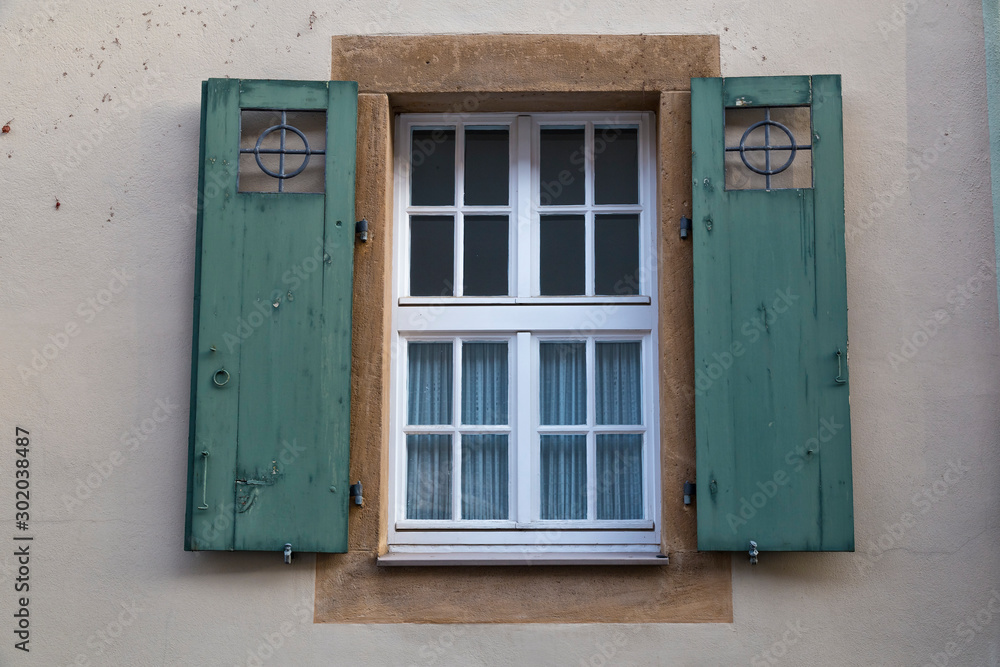 Ancient colorful window with open wooden shutters on wall of house