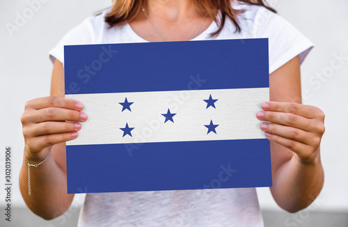woman holds flag of Honduras on paper sheet