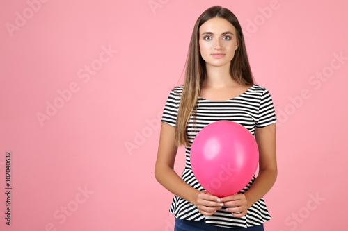 Young woman with balloon on pink background © 5second