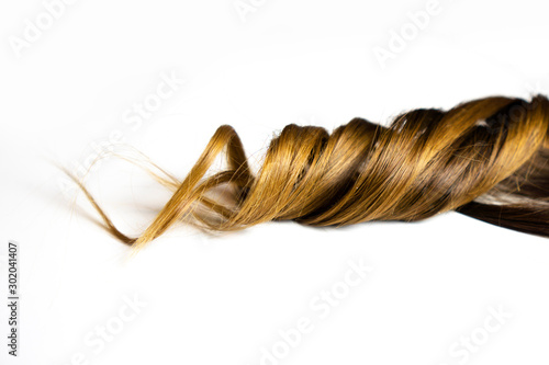 piece of brown curly hair on white isolated background