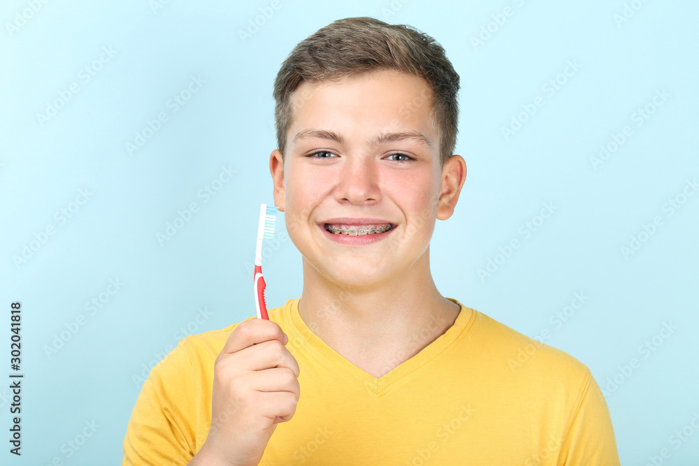 Young man with toothbrush on blue background Young man with toothbrush on blue background
