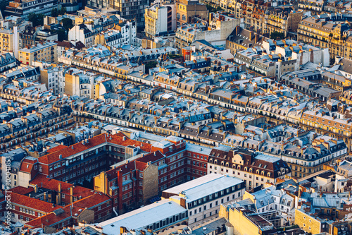 Classic Parisian buildings. Aerial view of roofs. Paris roofs panoramic overview at summer day, France. View of typical parisian roofs with mansards and chimneys in Paris, France.