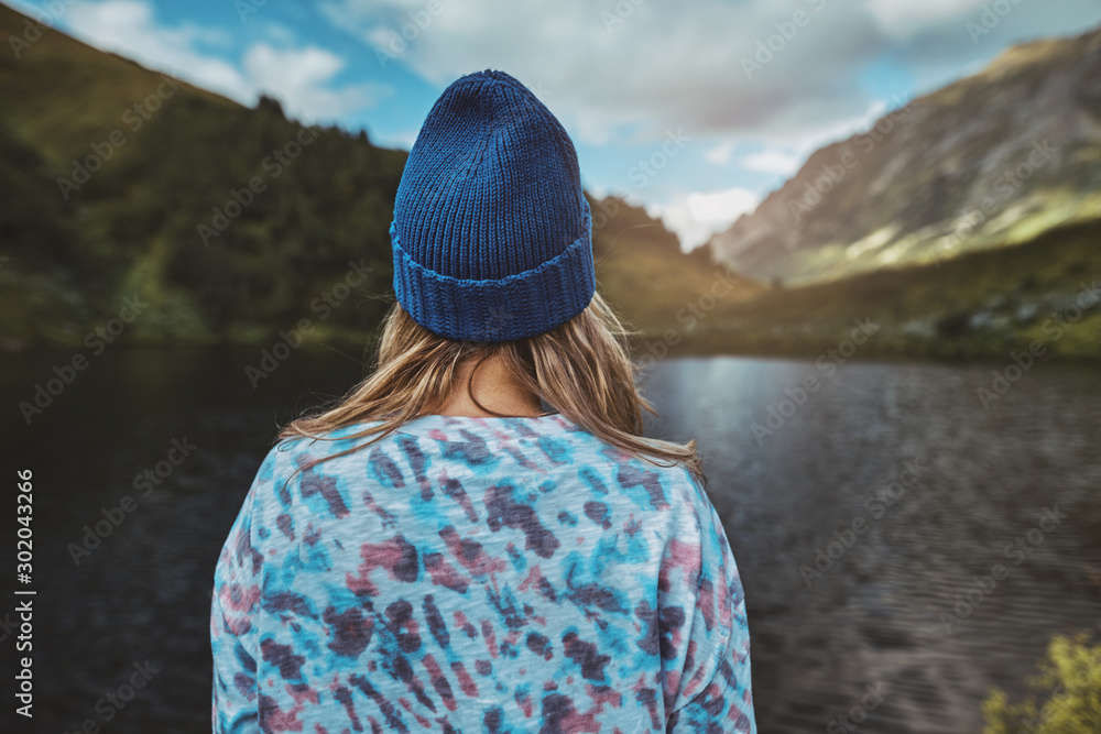 Woman hiker wearing winter hat enjoying lake view, Bzerpinsky karniz