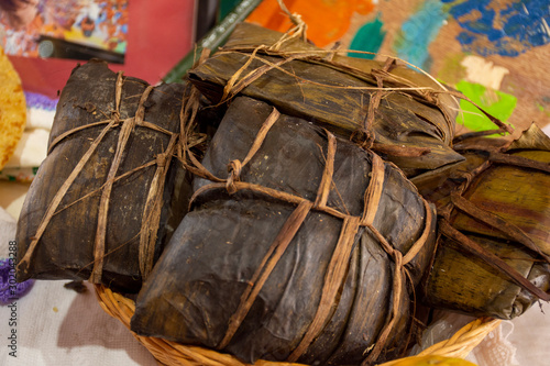 Canasta con tamales oaxaqueños envueltos en hoja de plátano photo