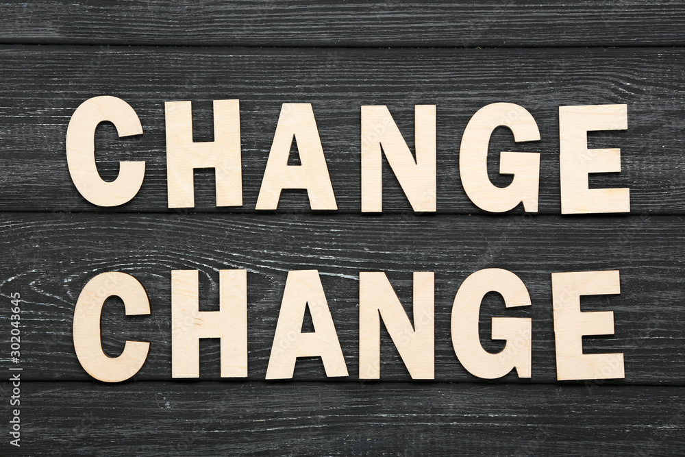 Word Change by wooden letters on black table Word Change by wooden letters on black table