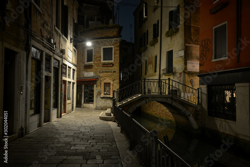 Venetian canal with bridge at night, Venice, Italy