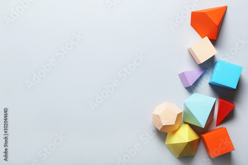Colorful paper geometric figures on grey background photo