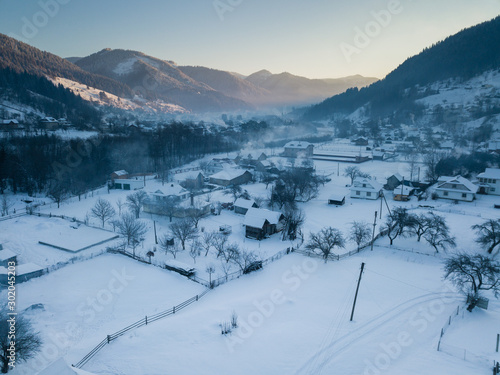 Wallpaper Mural Calm and cosy fairy-tale village Kryvorivnia covered with snow in the Carpathians mountains, aerial view. Typical landscape in Hutsulshchyna National Park in Ukraine. Vacation and winter sports. Torontodigital.ca