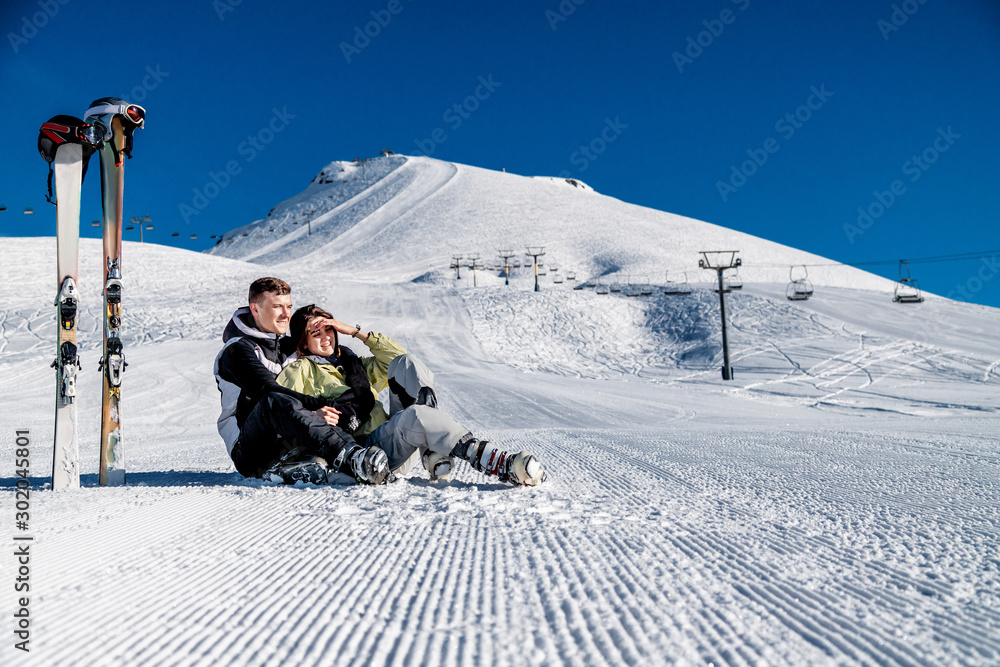 Young happy couple in snowy mountains. Winter sport vacation