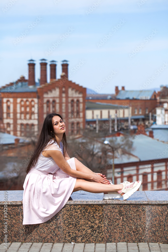 Young brunette woman in pink skirt and white blouse