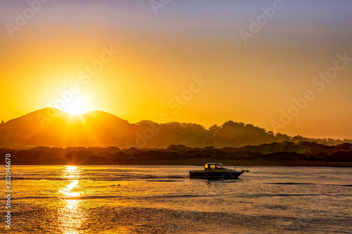 Sunrise over Silhouetted Mountain, Boat, River, Bay