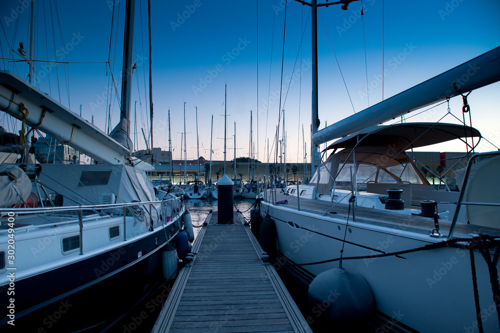 Fototapeta premium wooden surface pier and boats docked at dawn in the marina of Cartajena