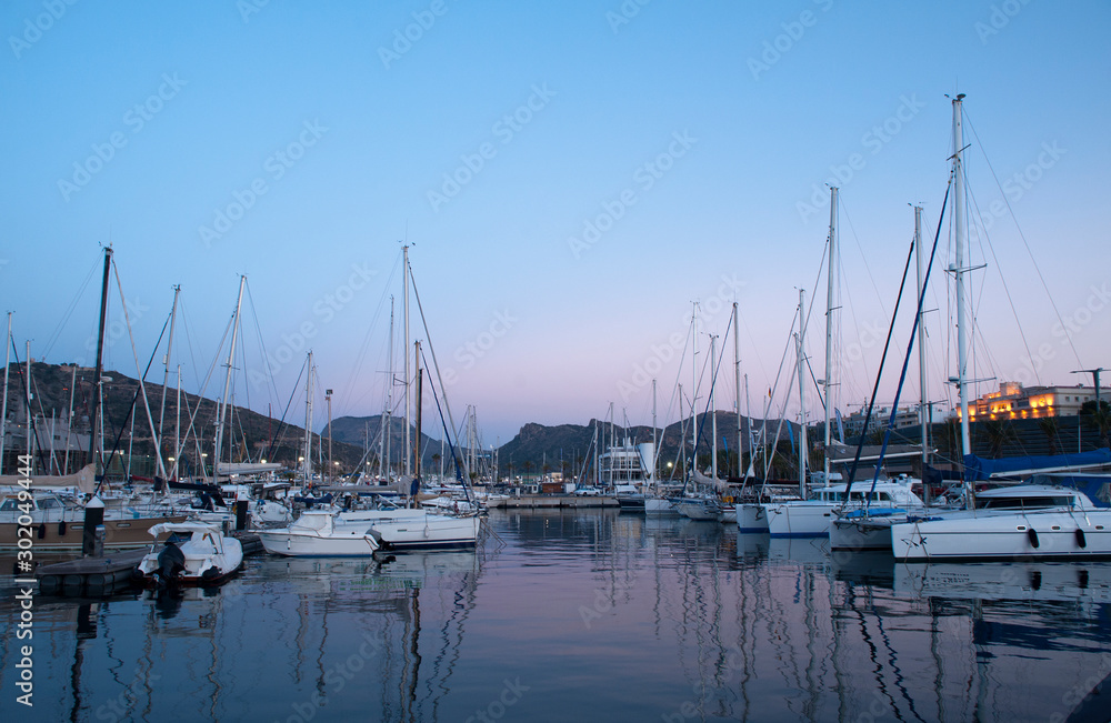 wooden surface pier and boats docked at dawn in the marina of Cartajena