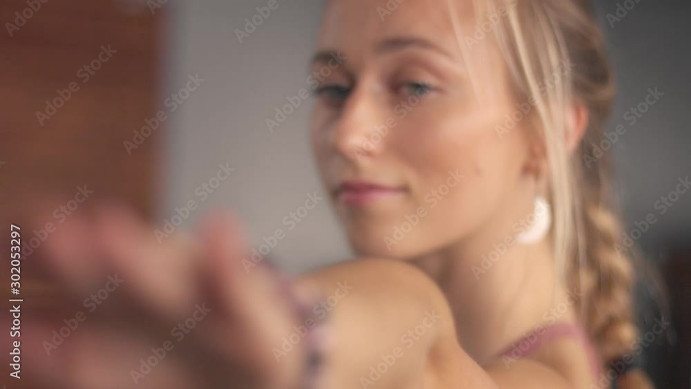 Closeup portrait with a soft focus while blonde woman makes a home werkout. Zoom out Closeup portrait with a soft focus while blonde woman makes a home werkout. Zoom out