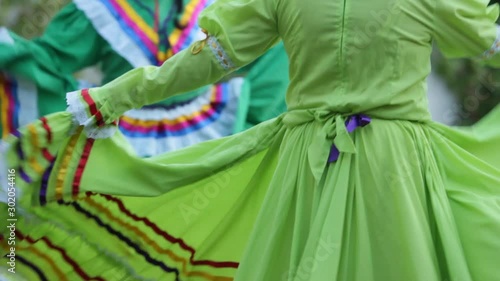 close up of a two mexican female dancers waving their colorful mexican folk dresses, mariachi music photo