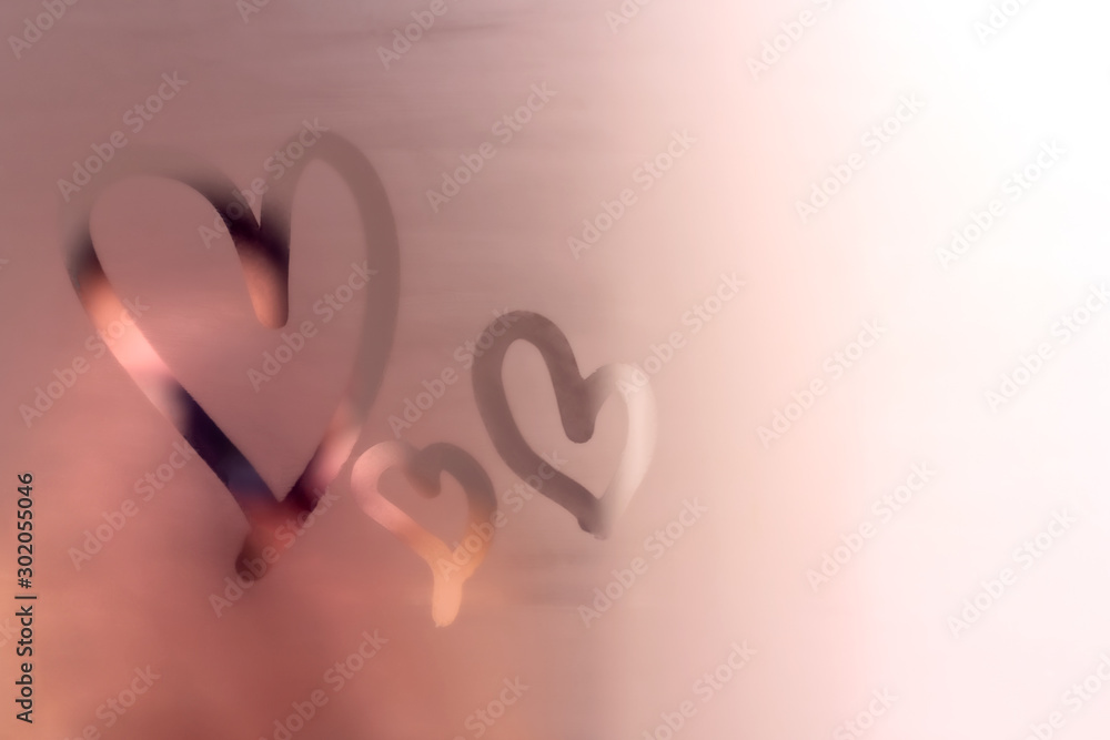 Fototapeta Three abstract hearts painted on fogged bathroom mirror. Finger drawing on glass. Romantic love background for congratulations on Valentine's Day. Template or card with free space for you text