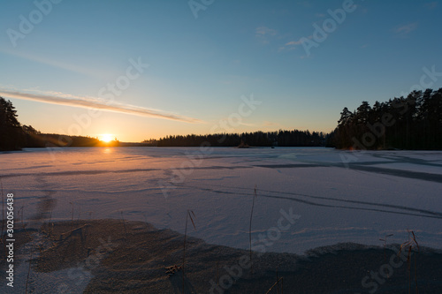 Sunrise behind a frozen lake in Finland