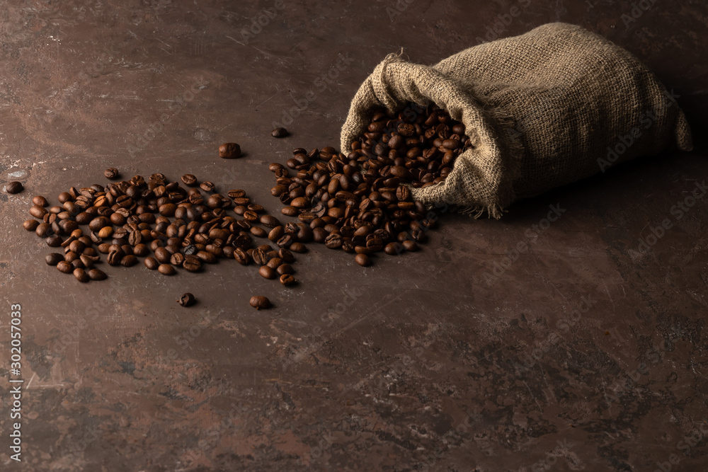 Obraz premium Roasted coffee beans in a bag on old rusty background with copy space