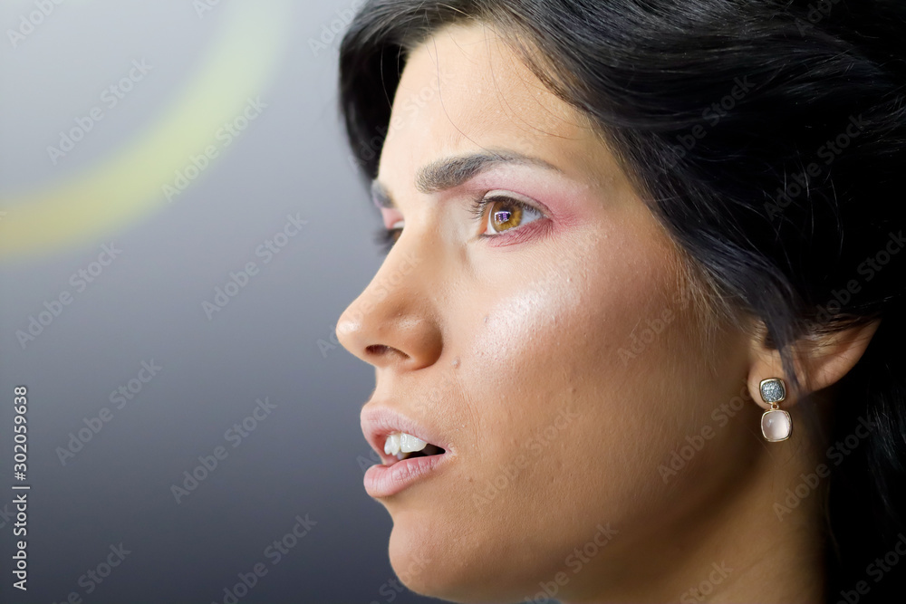 side profile of surprised look on model face, eyes and mouth open, close up on gray background side profile of surprised look on model face, eyes and mouth open, close up on gray background