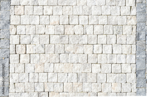 European stone pavement made of white blocks. Beautifully and evenly laid out square pavers in the city of Europe. Smooth white granite.