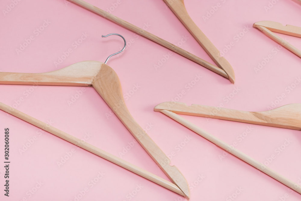 wooden empty clothes hangers on a pink background. concept: pop modern sale wooden empty clothes hangers on a pink background. concept: pop modern sale