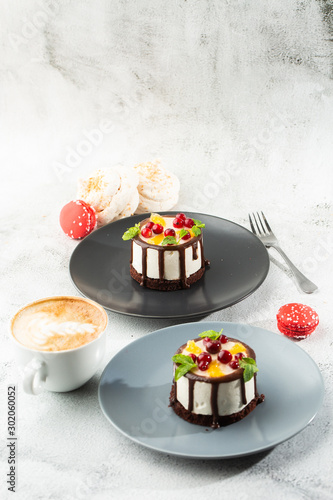 Mini round souffle cake with fruit and chocholate glaze on topc on marble background. Wallpaper for pastry cafe or cafe menu. vertical. photo