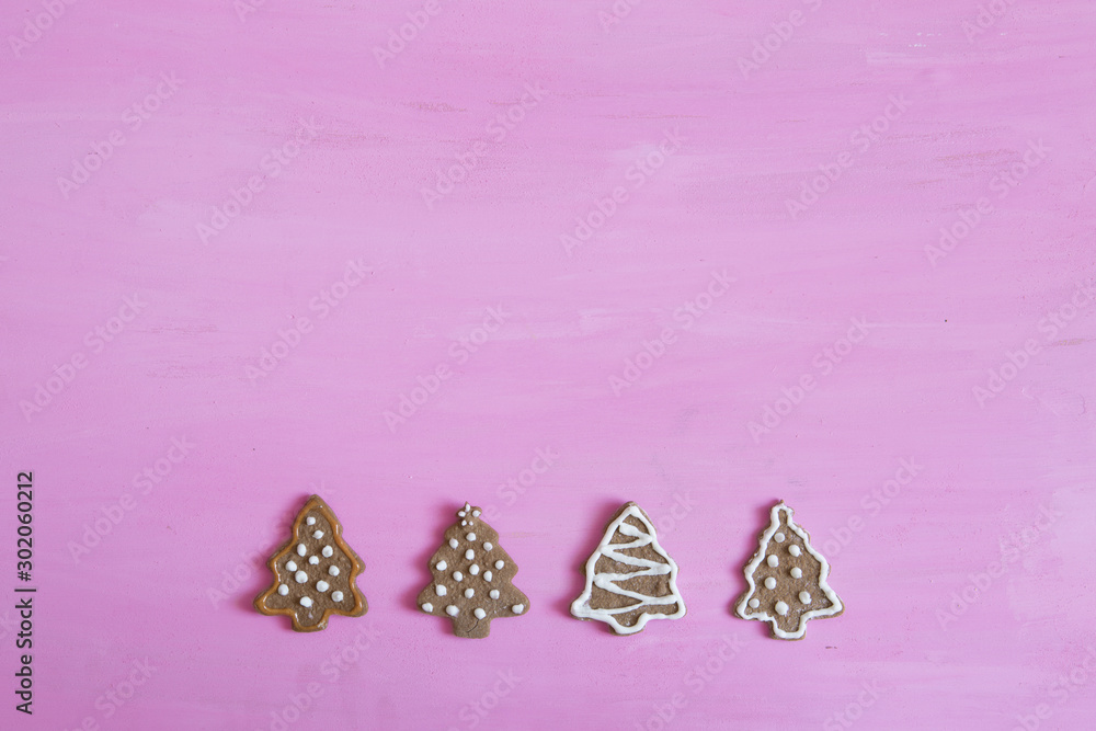 Line of Gingerbread cookies on pink wooden table. Close up, top view