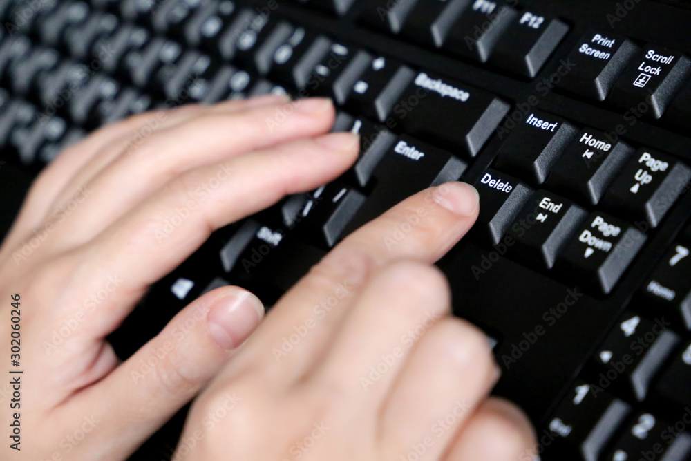 Female hands on computer keyboard close up, selective focus. Woman presses the Delete key, concept of error correction Female hands on computer keyboard close up, selective focus. Woman presses the Delete key, concept of error correction