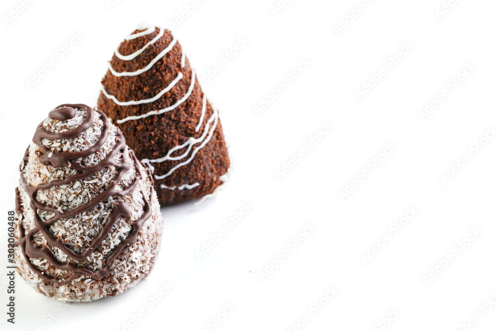 Two chocolate brownies . One is poured with white chocolate and sprinkled with cocoa, the second is poured with dark chocolate and sprinkled with coconut. Isolated on a white background. Two chocolate brownies . One is poured with white chocolate and sprinkled with cocoa, the second is poured with dark chocolate and sprinkled with coconut. Isolated on a white background.