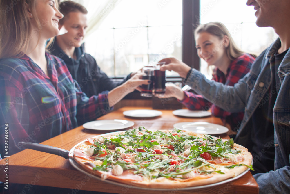 friends of classmates eat pizza in a pizzeria, students at lunch eat fast food friends of classmates eat pizza in a pizzeria, students at lunch eat fast food