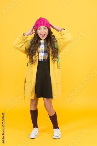 Fashion for enjoying school life to fullest. Happy child wear fashion style yellow background. Fashion look of small girl. Fashion trends for school