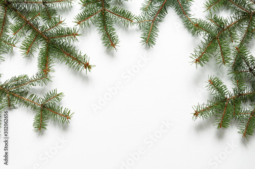 Christmas flat lay. Fir branches on white background with copy space, top view.