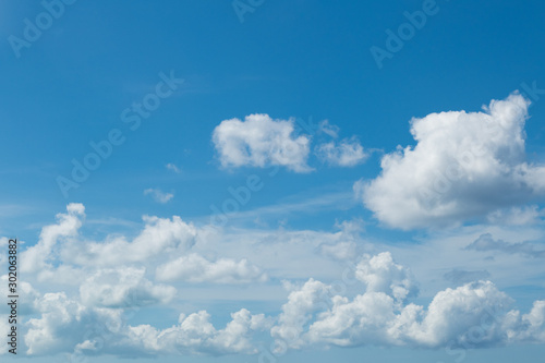 Beautiful natural sky background: white cumulus clouds on blue sky © ilyaska