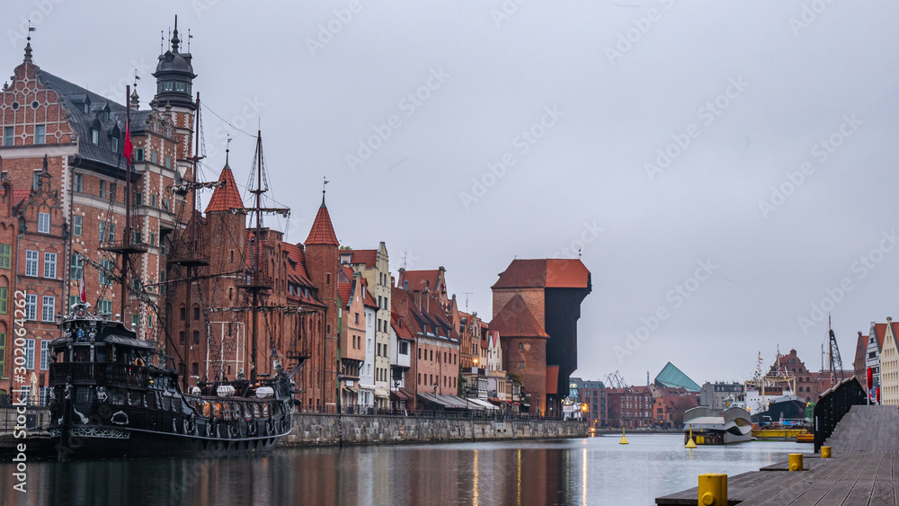 Obraz premium City Gdansk in Poland with the oldest medival port crane called Zuraw and a promenade along the riverbank of Motlawa River. November.