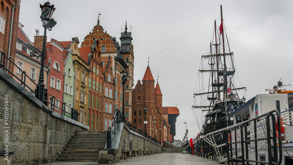 City Gdansk in Poland with the oldest medival port crane called Zuraw and a promenade along the riverbank of Motlawa River. November.