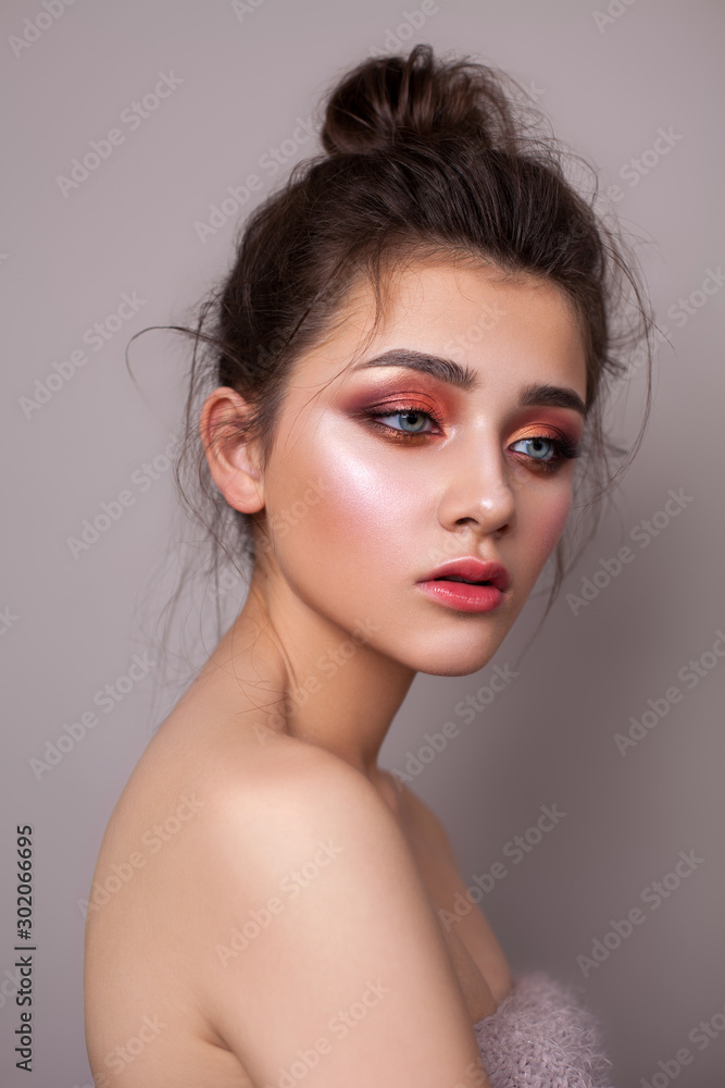 Attractive young girl with bright colorful trendy smoky eyes, blue eyes and bun hairstyle. Attractive young girl with bright colorful trendy smoky eyes, blue eyes and bun hairstyle.
