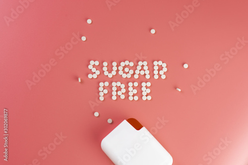 sweetener tablets on pink background photo