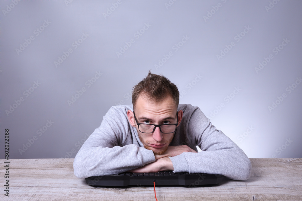 Funny nerd young businessman, man working on computer.Typing on the keyboard programmer in glasses in front of computer. Funny nerd young businessman, man working on computer.Typing on the keyboard programmer in glasses in front of computer.