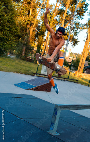 Portrait of skateboarder doing a trick in a skate park over the ramp 