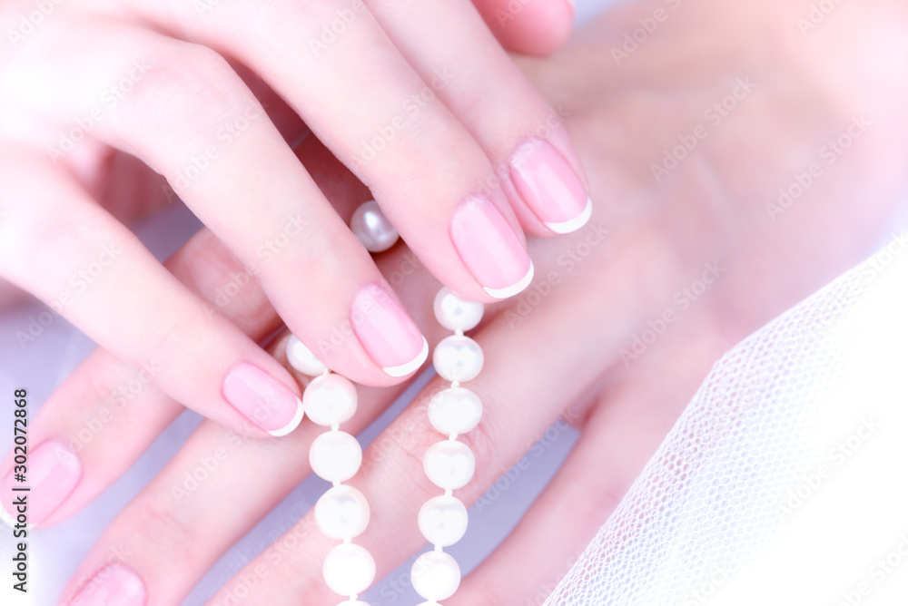Wedding manicure. Female hand with french manicure on a white background.