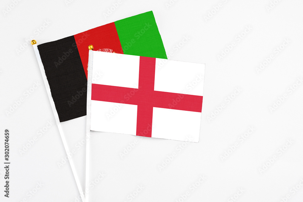England and Afghanistan stick flags on white background. High quality fabric, miniature national flag. Peaceful global concept.White floor for copy space.